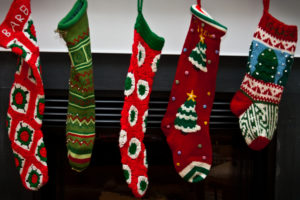 5 Christmas stockings hung on fireplace mantle