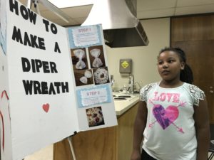 Little girl giving presentation with posterboard