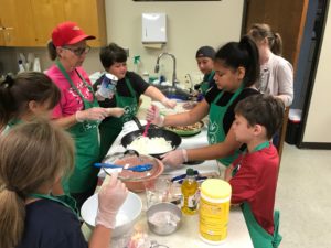 Children cooking under adult supervision