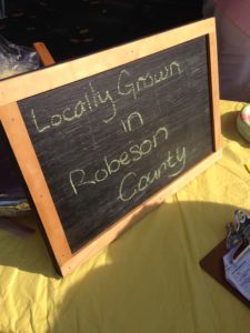 Chalkboard sign saying "Locally grown in Robeson County"