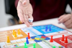 man rolling dice on board game