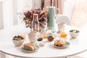 various breakfast foods on table with flowers